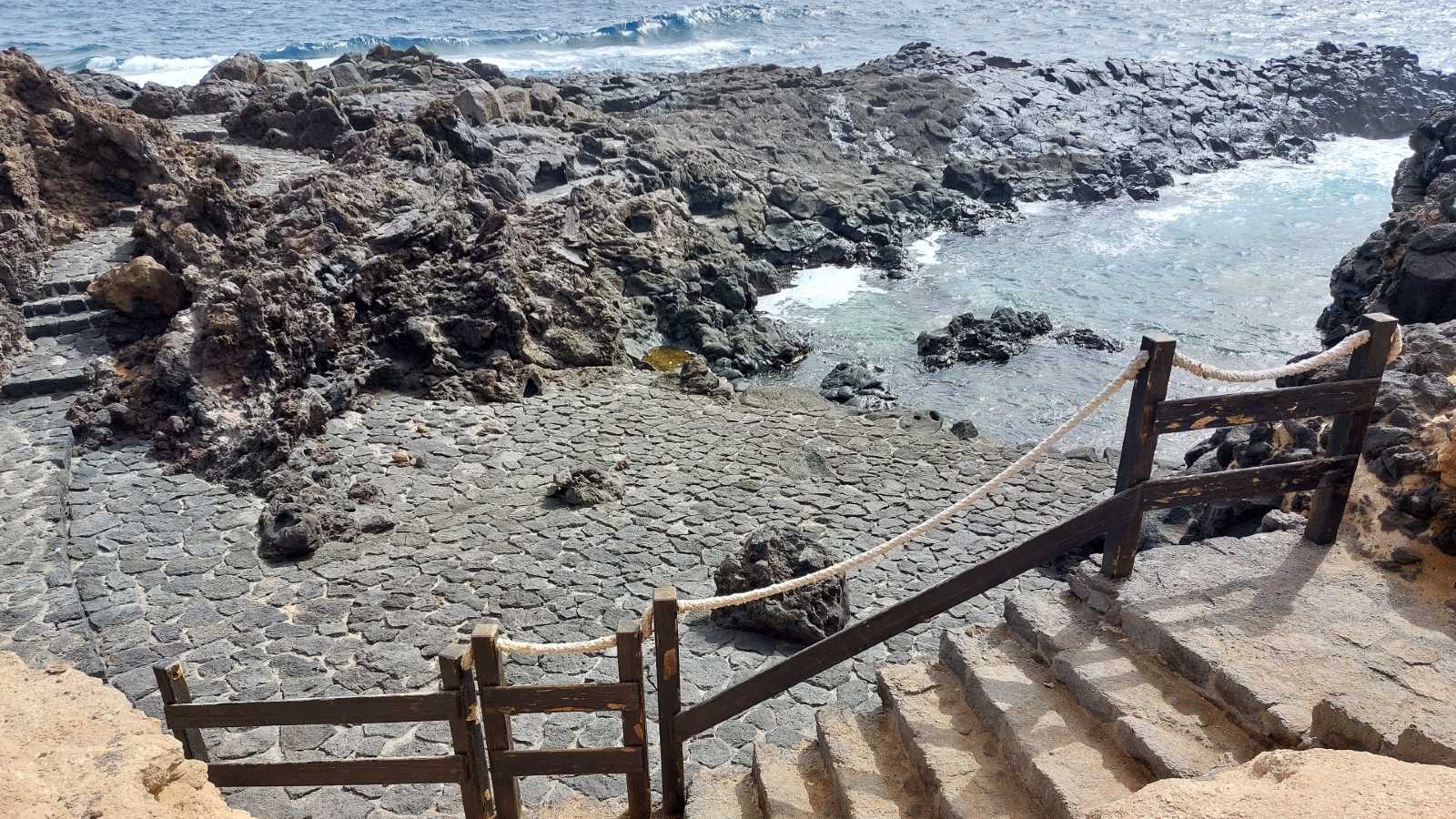 Superbe piscine avec une surface de bronzage en pierre volcanique sur la côte de Los Silos